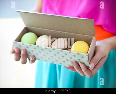 Mädchen in Händen hält, bunte französische Macarons Stockfoto