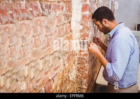 Nachdenklich Geschäftsmann gegen Mauer stehend Stockfoto