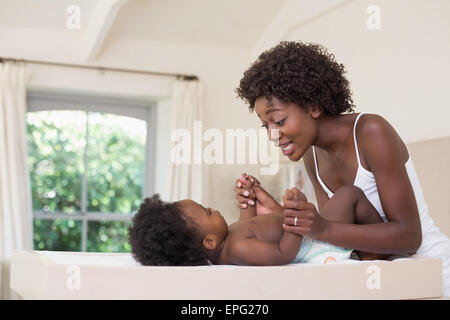 Glückliche Mutter mit Baby Girl am Wickeltisch Stockfoto