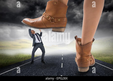 Zusammengesetztes Bild Cowboystiefel auf Geschäftsmann treten Stockfoto