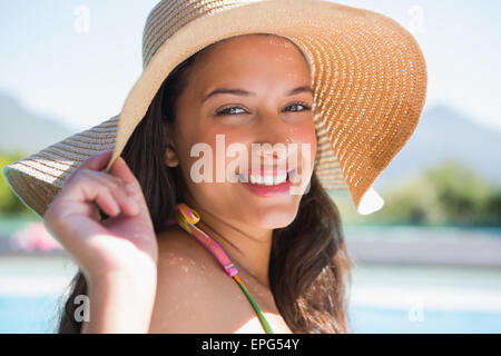 Schöne Brünette sitzt Pool tragen Stroh Sonnenhut Stockfoto