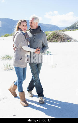 Lächelnde paar spazieren am Strand in warme Kleidung Stockfoto