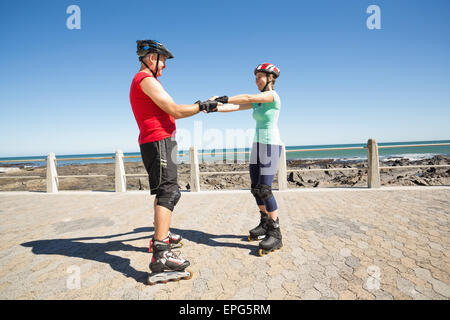 Älteres Paar Inline-Skating auf der Pier passen Stockfoto