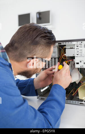 Informatiker arbeiten an defekten Konsole mit Schraubendreher Stockfoto