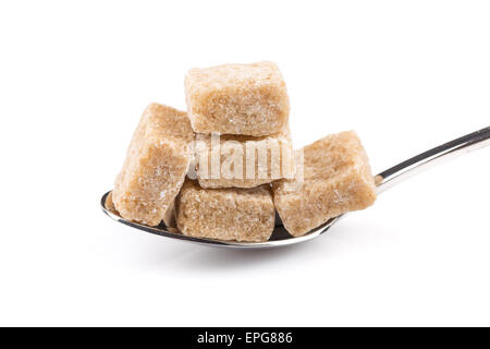 Würfel aus braunem Zucker auf einem Metalllöffel Stockfoto