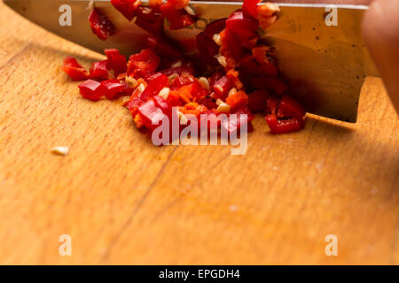 Ein Messer benutzt, um eine rote Chilischote hacken Stockfoto