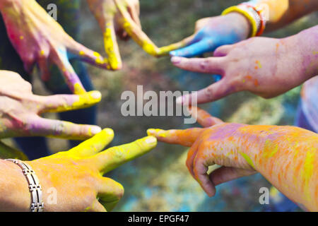 Freunde, die ihre Hände als Zeichen der Einheit und Teamarbeit zusammenzustellen. Holi Farben festival Stockfoto