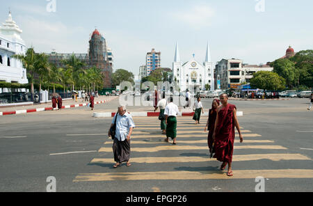 Mönche und Menschen überqueren Sie die Straße in down Town Yangon Myanmar Stockfoto