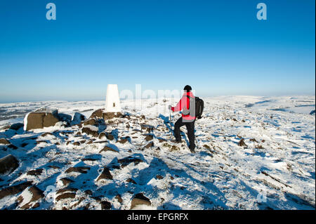 Walker im Schnee, die Aussicht auf Shutlinsloe & Cheshire aus The Roaches, Peak National Park, Staffordshire, England. Stockfoto