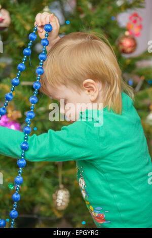 Blonder Junge schmückt Weihnachtsbaum Stockfoto