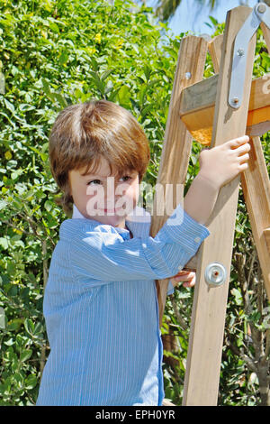 Der junge mit einem Lächeln posiert auf Trittleiter Stockfoto