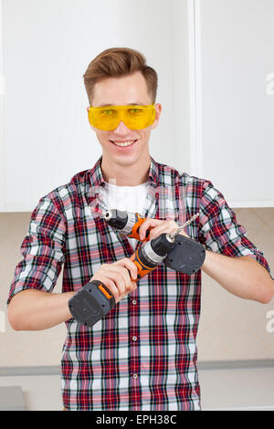 Arbeiter mit Bohrmaschine und Schraubendreher Stockfoto