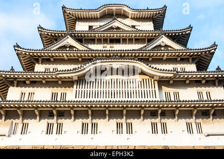 Der sonnenbeleuchtete Borogata-Stil halten des Himeji Schloss in Japan, während der Nachmittag goldene Stunde gegen einen blauen Himmel mit einigen weißen Wolken in. Stockfoto