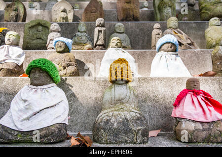 Steintreppe mit vielen Izo bosatsu Statuen. Die kleinen japanischen Statuen, viele mit Lätzchen und Wollmützen, ordentlich in Reihen auf den Stufen angeordnet. Stockfoto