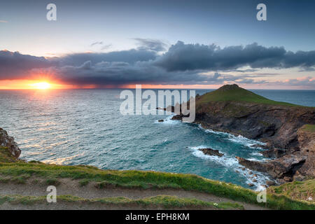 Ein dramatischer Sonnenuntergang wie Gewitterwolken über der Bürzel, einer Küstenstadt Landzunge ragt auf den Atlantischen Ozean im Norden zu sammeln Stockfoto