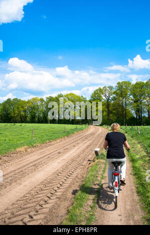 Frau auf Fahrrad am Feldweg in den Niederlanden Stockfoto