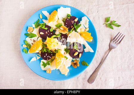 Salat mit Roter Beete, Walnüsse, Kohl und Orange auf blau Teller, vegetarische Kost Stockfoto