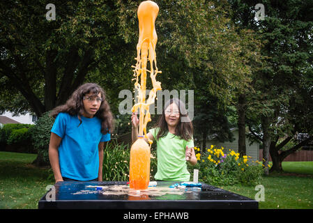 Zwei Mädchen im Teenageralter experimentieren mit Kombination von Mentos und Limonaden, was zu riesigen Explosion. Stockfoto