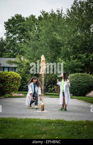 Zwei Mädchen im Teenageralter experimentieren mit Kombination von Mentos und Limonaden, was zu riesigen Explosion. Stockfoto