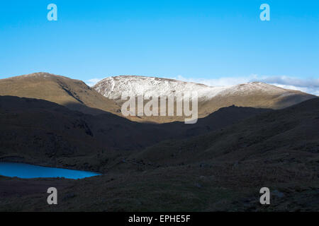 Sonnenlicht fangen die Schnee bedeckten Gipfel des Fairfield von in der Nähe von Easedale Tarn über Grasmere Cumbria England Stockfoto