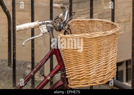 Roten Fahrrad mit Zuckerrohr Korb in Oxford, England, Oxfordshire, Vereinigtes Königreich. Radfahren ist eine beliebte Art des Verkehrs rund um diese berühmte Stadt. Stockfoto