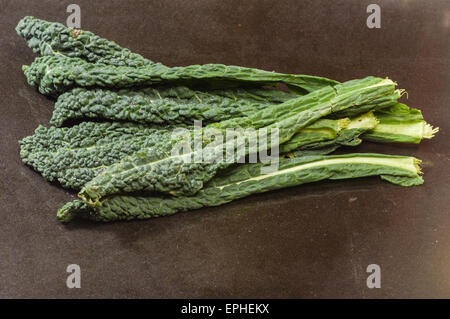 Frische grüne Kohl verlässt auf schwarze Theke Stockfoto