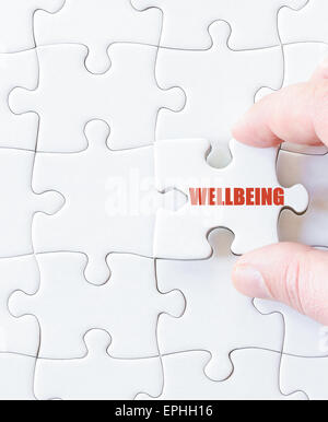 Fehlende Jigsaw Puzzlestück mit Wort Wohlbefinden. Konzept-Bild für den Abschluss der Puzzle. Stockfoto