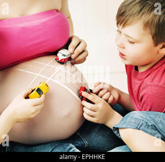 Jungs spielen mit einem ungeborenen Bruder Stockfoto