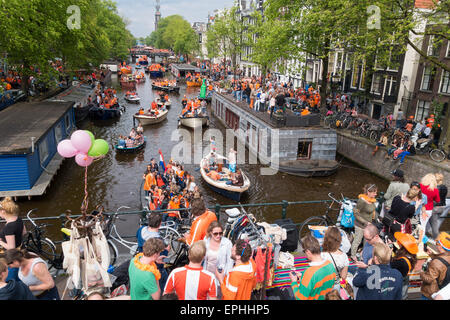 Massen Koningsdag, Kings-Tages-Festival in Amsterdam w Boote am Prinsengracht Kanal und Vrijmarkt auf der Brücke zu feiern. Stockfoto