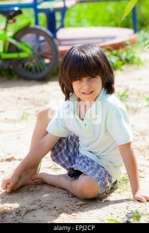 Junge sitzt auf dem sand Stockfoto