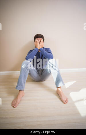 Deprimiert Mann sitzt am Boden Stockfoto