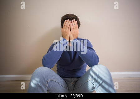 Deprimiert Mann sitzt am Boden Stockfoto