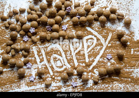 Schokokugeln auf einem Tisch mit dem Wort Happy geschrieben in der Schokolade Stockfoto