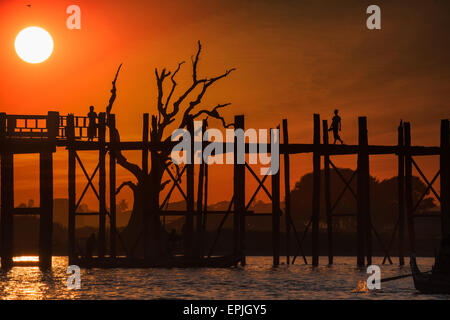 Silhouetten bei Teak U Bein Brücke. Einheimische und Touristen genießen Sonnenuntergang in Amarapura. Myanmar (Burma) Reisen Landschaften und Stockfoto