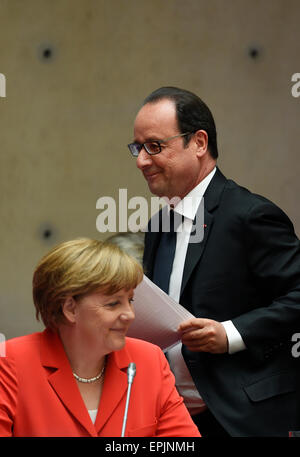 Berlin, Deutschland. 19. Mai 2015. Der französische Präsident Francois Hollande (wieder) geht vorbei an Bundeskanzlerin Angela Merkel während der Petersberg Climate Dialogue-Konferenz in Berlin, Deutschland, 19. Mai 2015. Informelle Treffen der Minister und Vertreter von rund 35 Ländern ist vom 18. bis 19. Mai 2015 in Vorbereitung auf die UN-Klimakonferenz in Paris statt. Bildnachweis: Dpa picture Alliance/Alamy Live News Stockfoto