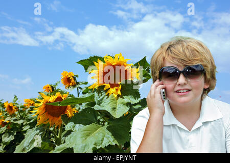 Thel blonden Jungen reden über Handy Stockfoto