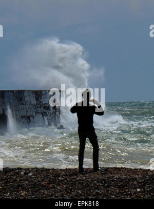 Newhaven, Sussex, UK. 19. Mai 2015. Ein Mann fotografiert am Strand wie riesige Wellen Absturz über Newhaven Hafenmauer am Leuchtturm heute Stockfoto