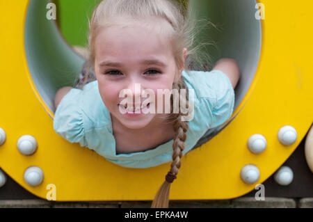 Entzückende junge Mädchen sitzen im Crawl-Rohr Stockfoto