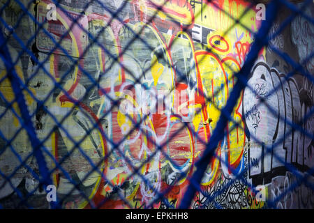 Graffiti-Kunst an einer Wand in Williamsburg, Brooklyn in New York gesehen durch einen Maschendrahtzaun am Donnerstag, den 14. Mai 2015 Stil. © Richard B. Levine) Stockfoto