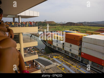 Panama, Provinz Panama, Panama-Stadt, Touristen beobachten Containerschiff auf der Durchreise der Miraflores-Schleusen des Panama-Kanals Stockfoto