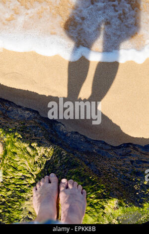 USA, Hawaii, Hanalei, Füße auf moosbewachsenen Stein am Strand Stockfoto