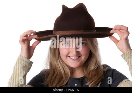 Porträt eines acht Jahre alten glücklich blonden Mädchens mit alten braunen Hut auf weißem Hintergrund Stockfoto