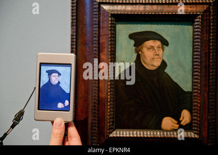 Das Porträt von Martin Luther im Alter von 50 (1533) von Lucas Cranach der älteren man an der Wand und auf einer speziell angefertigten audio Guide vor der Eröffnung der Ausstellung sieht "zwischen Venus und Luther: Cranachs Medien der Versuchung" auf Germanisches Nationalmuseum (Germanische Nationalmuseum) in Nürnberg, 18. Mai 2015. Das Museum stellt die Werke von Lucas Cranach der ältere (1472-1553) in den Fokus bei Gelegenheit der Lutherdekade. Etwa zwanzig Werke, die dauerhaft auf Ausstellung werden in einem kulturell-historischen Kontext in einer neuen Präsentation erläutert. Foto: Daniel Karmann/dpa Stockfoto