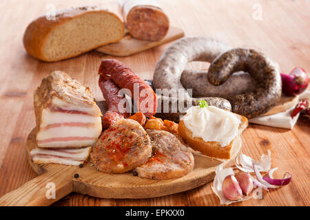 Blutwurst, Reis Wurst, Kopf Käse, Knoblauch, Zwiebel-Bier und Brot auf Holzküche Brett auf hölzernen Hintergrund. Traditionelle Stockfoto