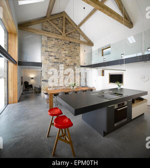 Schwarze moderne Insel Gerät in großen, offenen Plan, hohe Decken Küche/Esszimmer, Cat Hill Barn, South Yorkshire, England, UK Stockfoto