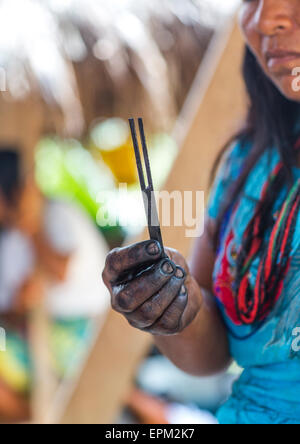 Panama, Provinz Darien, Bajo Chiquito, Frau von der einheimischen indischen Embera zeigt einen Stick für Jagua Bodypaint Stockfoto