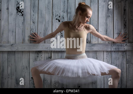 Stand in der Nähe einer Holzwand auf Pointe Ballerina Stockfoto