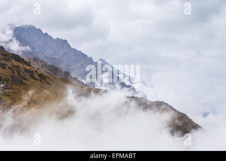 Schroffen Gipfeln zeigt über Wolken auf die Remarkables Ski Area, Queenstown, Neuseeland. Stockfoto