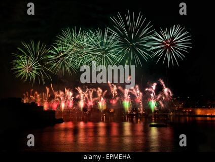 Feuerwerk. Buntes Feuerwerk mit Valletta Hintergrund, große Explosion, Haus Licht, Grüne Spiegelungen auf dem Wasser in Valletta Stockfoto
