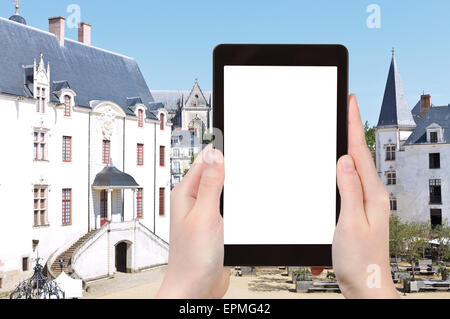 Reisekonzept - Touristen fotografieren Hof im Schloss der Herzöge der Bretagne in Nantes, Frankreich auf Tablet-pc mit ausgeschnittenen scr Stockfoto